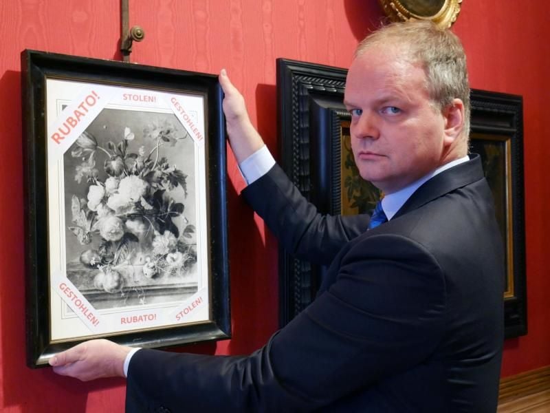 Eike Schmidt, deutscher Direktor der Uffizien, mit einer Fotografie des Ölgemäldes „Vaso di Fiori” von Jan van Huysum. Foto: Uffizien-Gemäldegalerie Florenz