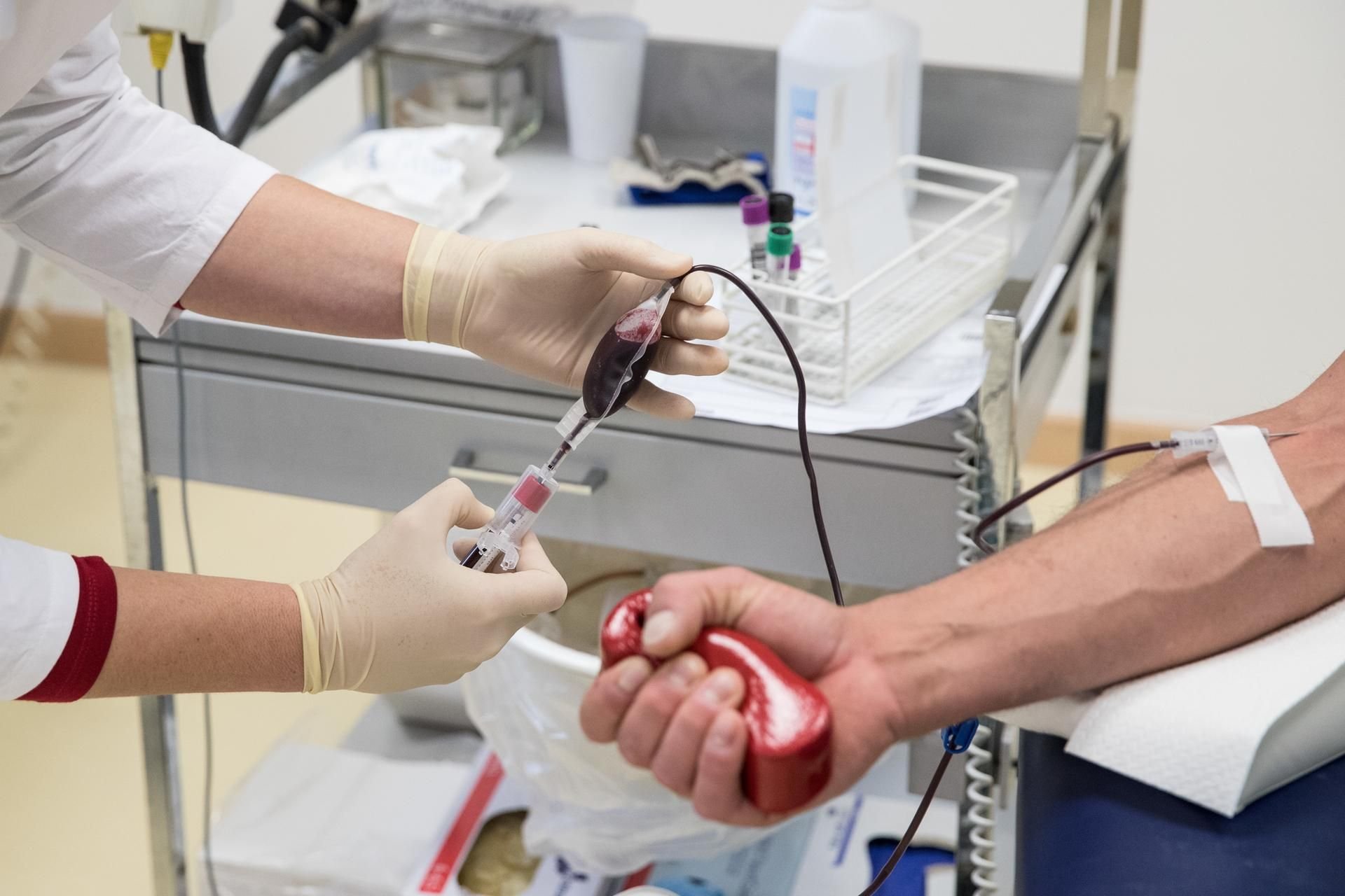 Eine Mitarbeiterin entnimmt beim DRK-Blutspendedienst einem Blutspender Blut.