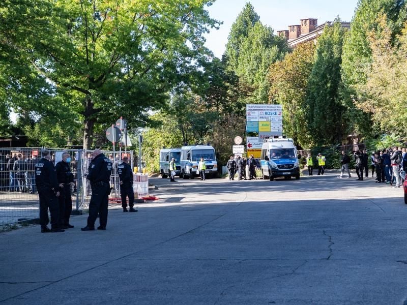 Polizisten stehen am Eingang zum Neuen-Zwölf-Apostel-Friedhof in Schöneberg. Die Beerdigung einer Mutter aus einem bekannten arabischstämmigen Clan in Berlin wird von der Polizei mit 200 Beamten begleitet. Foto: Paul Zinken/dpa
