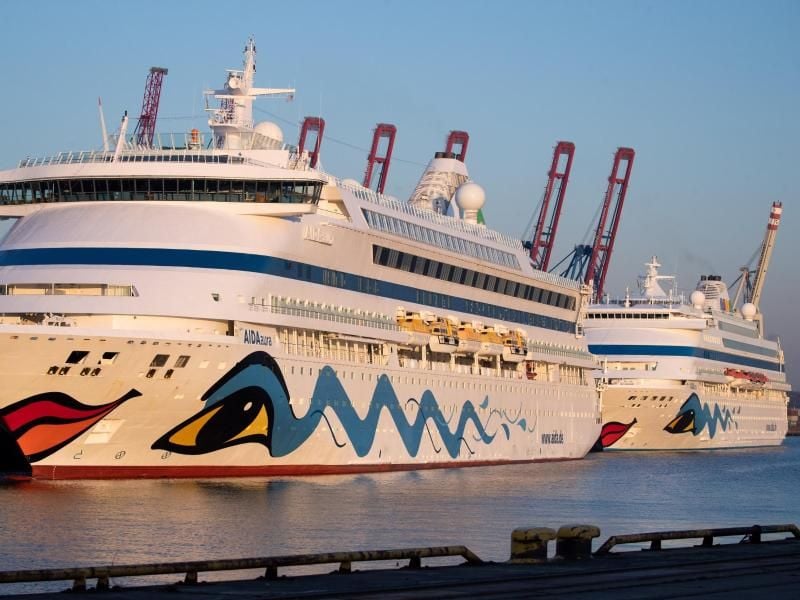 Schiffe der Aida-Cruises liegen im Hafen. Foto: Christian Charisius/dpa