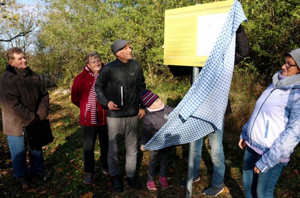 Vereinsvorsitzender Andreas Neubert überlässt der sechsjährigen Clara Strechel die Ehre, die neue Informationstafel am Saale-Radweg bei Latdorf zu enthüllen.
