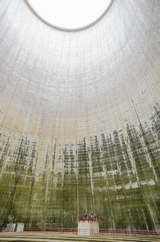 Die beiden Arbeiter am Fuß des Kühlturms in Schkopau sind angesichts dessen schierer Größe kaum wahrnehmbar.