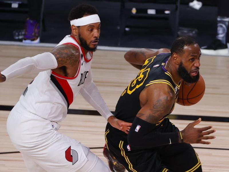 LeBron James (r) von den Los Angeles Lakers und Carmelo Anthony von den Portland Trail Blazers in Aktion. Foto: Kevin C. Cox/Pool Getty Images/AP/dpa