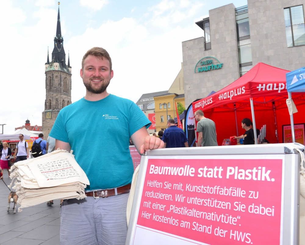 Dario Mattstedt von den Stadtwerken verteilt beim Umwelttag „Plastikalternativtüten“.