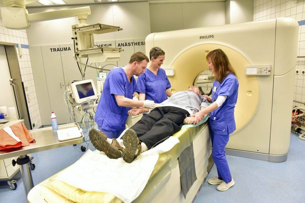 Marko Bertram, Antje Malz und Petra Zimmermann (v.l.n.r.) bereiten in der Notaufnahme einen Patienten zur Computertomographie vor.