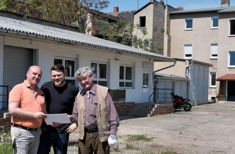 Ralf Schibrowski, Stefan Taig und Heinrich Holzwarth vor den Gebäuden, die abgerissen werden sollen.