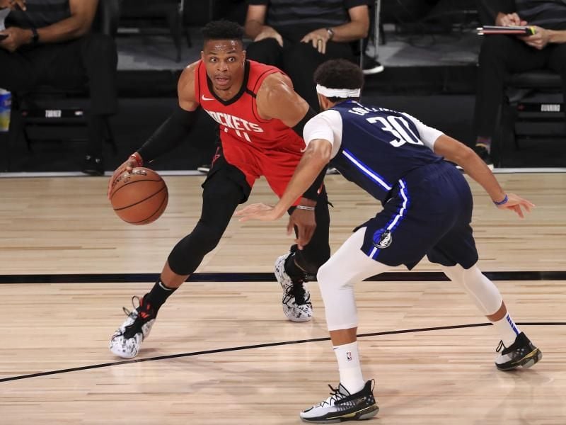 Russell Westbrook (l) von den Houston Rockets dribbelt gegen Seth Curry (r) von den Dallas Mavericks. Foto: Mike Ehrmann/POOL Getty Images/AP/dpa