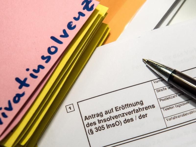 Das Wort „Privatinsolvenz” steht auf einem Trennblatt, während davor ein Antrag zur Eröfnung eines Insolvenzverfahrens liegt. Foto: Alexander Heinl/dpa/Illustration