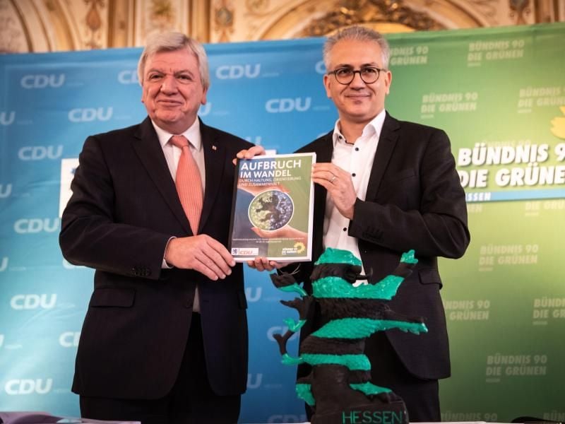 Volker Bouffier (CDU, l) und Tarek Al-Wazir (Grüne) zeigen den neuen Koalitionsvertrag für Hessen. Foto: Frank Rumpenhorst
