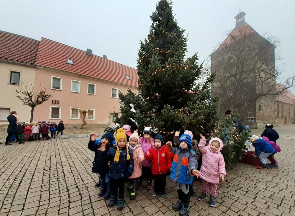 Die Kleinen der Kindertagesstätte bedanken sich für die Süßigkeiten, während eine Gruppe rechts noch schmückt.