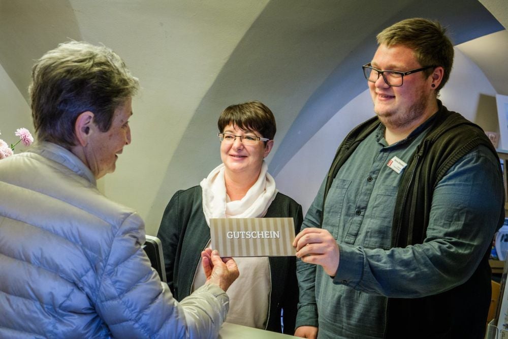 Andrea Slabik und Ronny Mitlehner von der Naumburger Tourist-Information zeigen Ursula Hübner (links) den Innenstadt-Gutschein.
