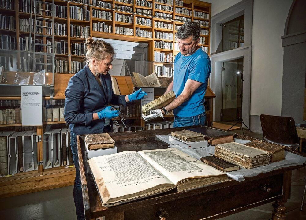 Restauratorin Annegret Philipsen und der Historiker Joachim Säckl begutachten in der Stiftsbibliothek Zeitz 500 Jahre alte Bücher.