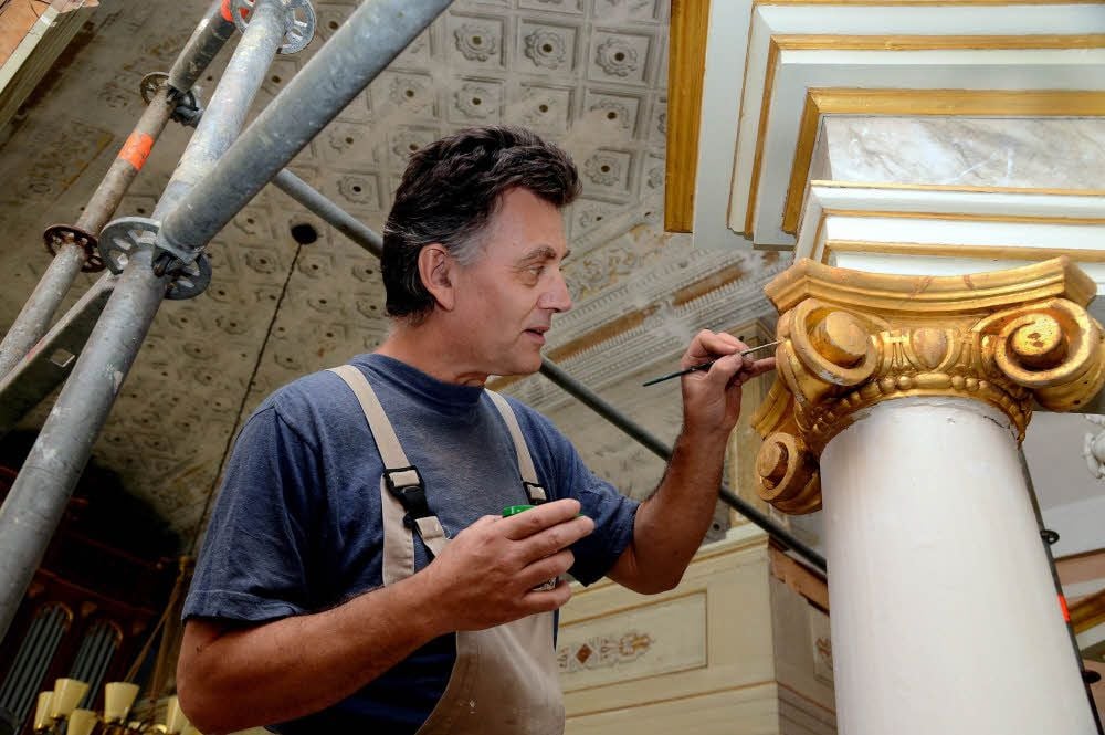 Diplom-Restaurator Thomas Götze aus Goseck trägt am Säulenkapitel Farbe mit Goldeffekt auf. Später wird er die Marmorierung neu gestalten.