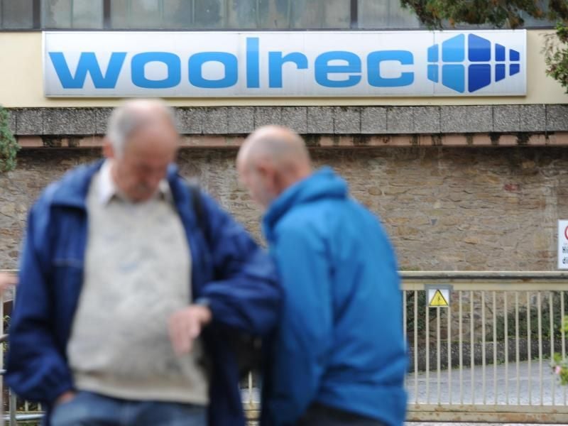 Zwei Männer stehen im mittelhessischen Braunfels vor der Zufahrt zum Woolrec-Firmengelände. Foto: Arne Dedert/dpa