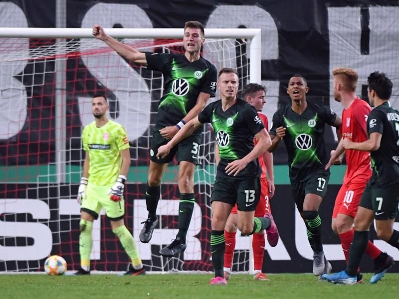 Halle-Keeper Kai Eisele (l-r) ist geschlagen, Wolfsburgs Robin Knoche feiert sein Tor zum 4:3. Foto: Hendrik Schmidt