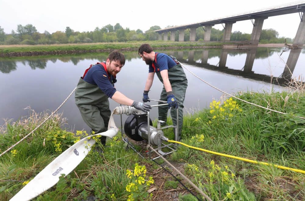 Sebastian Szerny und Andreas Allgäuer (v.l.) platzieren eine große Tauchpumpe in der Mulde. Damit wurde eine Wasserversorgung erprobt.