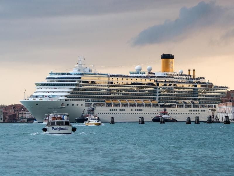 Das Kreuzfahrtschiff „Costa Deliziosa” durchquert die Lagune von Venedig - die Buchung einer Seereise ist im Reisebüro oder über ein Kreuzfahrtportal im Internet möglich. Beides hat Vor- und Nachteile. Foto: Andrea Warnecke/dpa-tmn