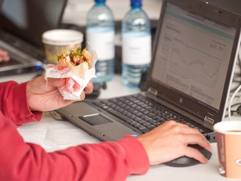 Ein Mann isst bei der Arbeit einen Döner. Will eine Firma das Essen am Arbeitsplatz verbieten, muss der Betriebsrat zustimmen. Foto: Sebastian Kahnert
