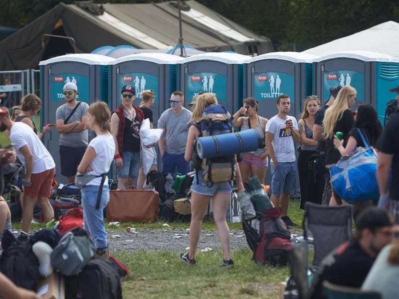 Wartende vor Mobiltoiletten am Rande des Musikfestivals "Rock am Ring" in Nürburg. Foto: Thomas Frey
