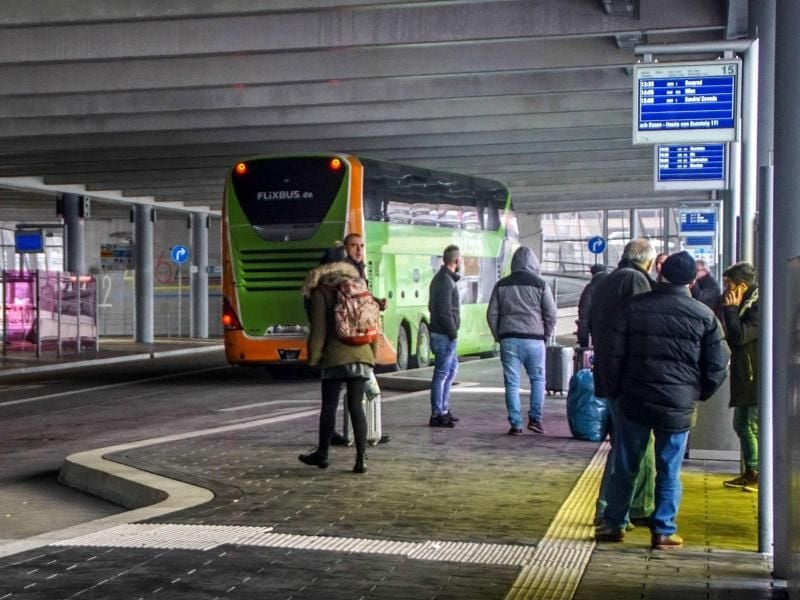 Reisende warten am Fernbus-Bahnhof am Flughafen in Stuttgart. Foto: Frank Dettenmeyer