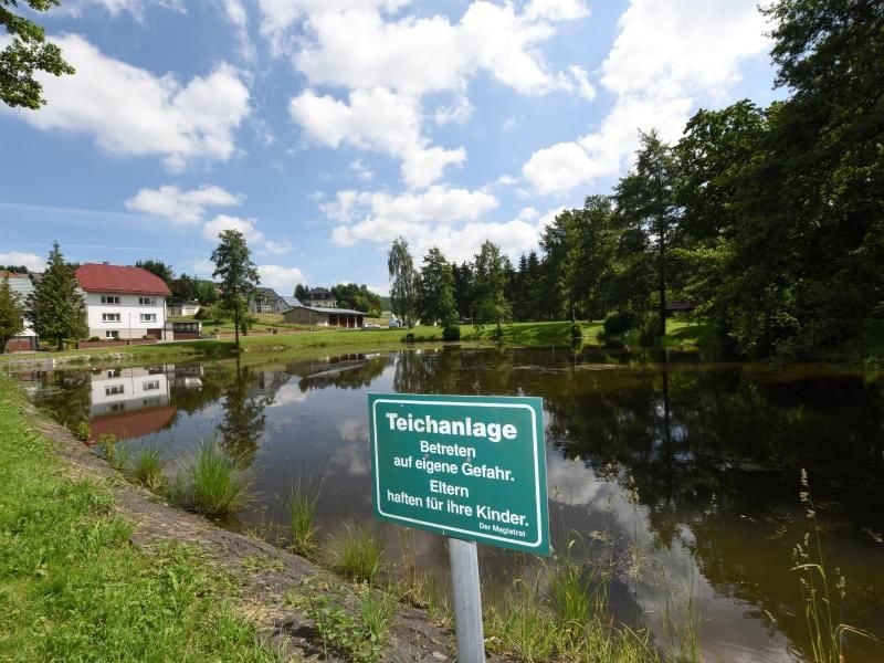 Ein Schild mit der Aufschrift „Teichanlage - Betreten auf eigene Gefahr. Eltern haften für ihre Kinder.”. Foto: Frank Rumpenhorst/Archivbild