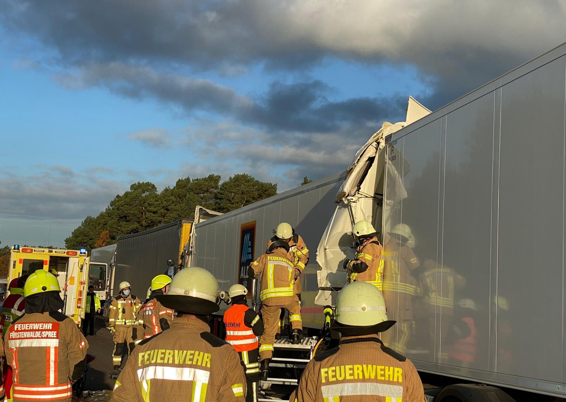 Einsatzkräfte der Feuerwehr stehen an der Unfallstelle auf der A12 zwischen Briesen und Fürstenwalde.