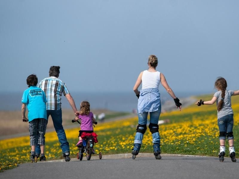 Ein Mann, eine Frau und drei Kinder fahren mit Inline-Skates, Fahrrad und Tretroller. Foto: Matthias Balk/Archiv