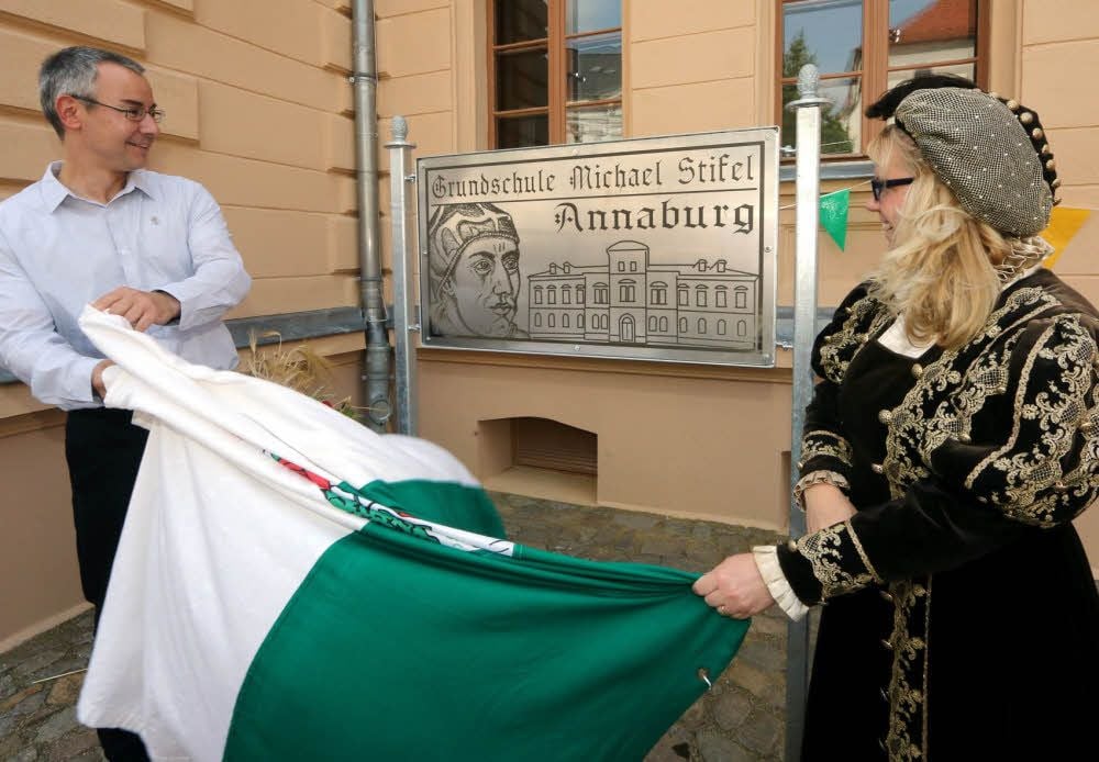Kurfürstin Anna (Stefanie Grolms) und Ortsbürgermeister Stefan Schmidt enthüllen das Namenschild der Grundschule Annaburg.