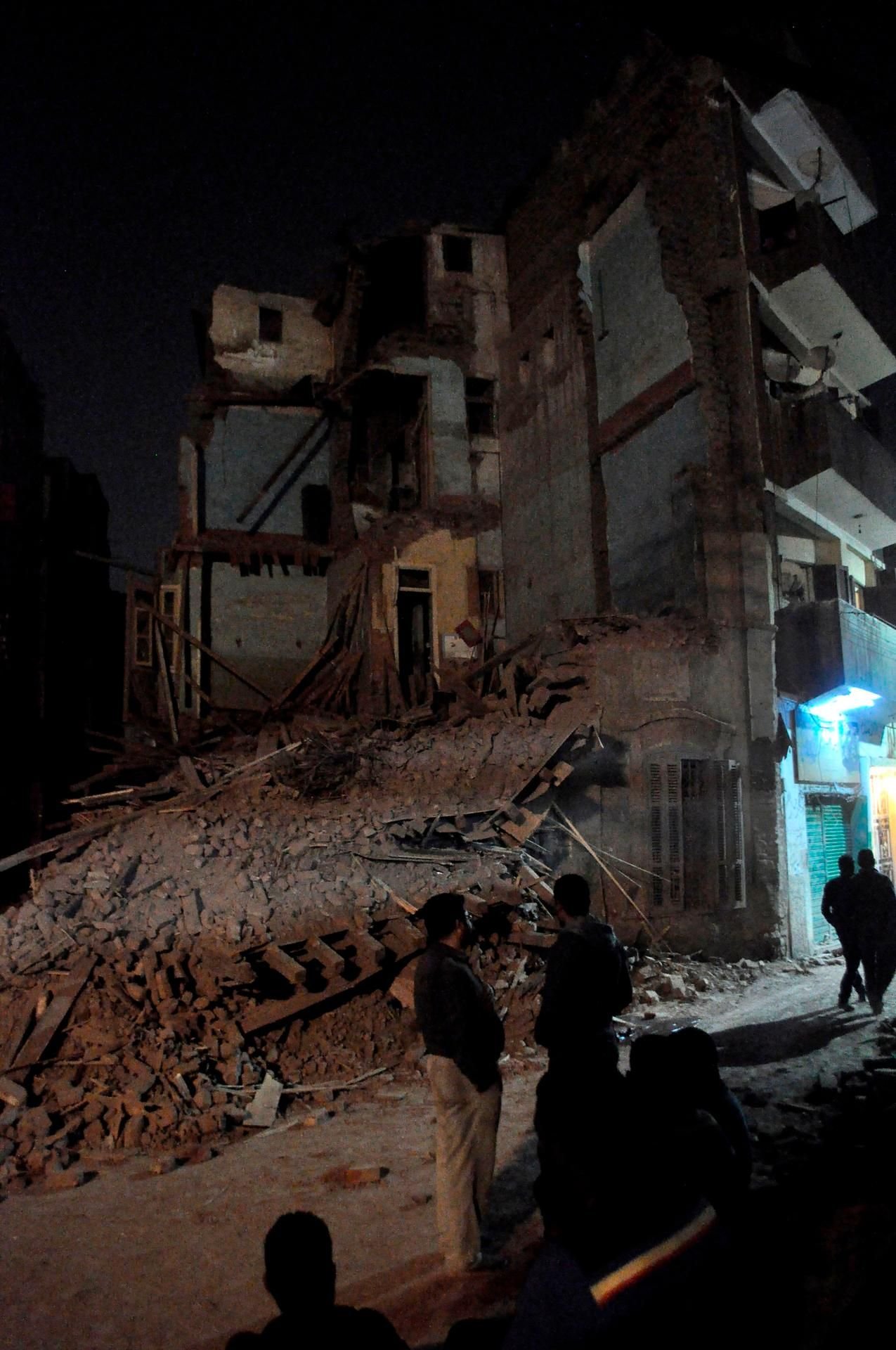 Menschen stehen vor dem eingestürzten Haus in der ägyptischen Stadt Luxor.