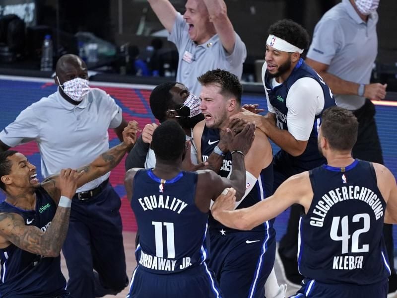 Luka Doncic (M) von den Dallas Mavericks feiert mit seinen Teamkollegen. Foto: Ashley Landis/Pool AP/dpa