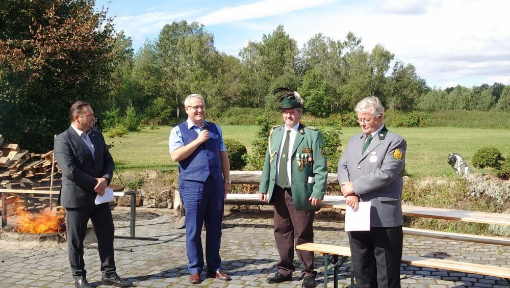 Frederik Sandner (v.l.), Präsident des Kreissportbundes, und Landrat Götz Ulrich gratulieren dem Großkaliber Schützenverein Lossa zum 25-jährigen Bestehen.