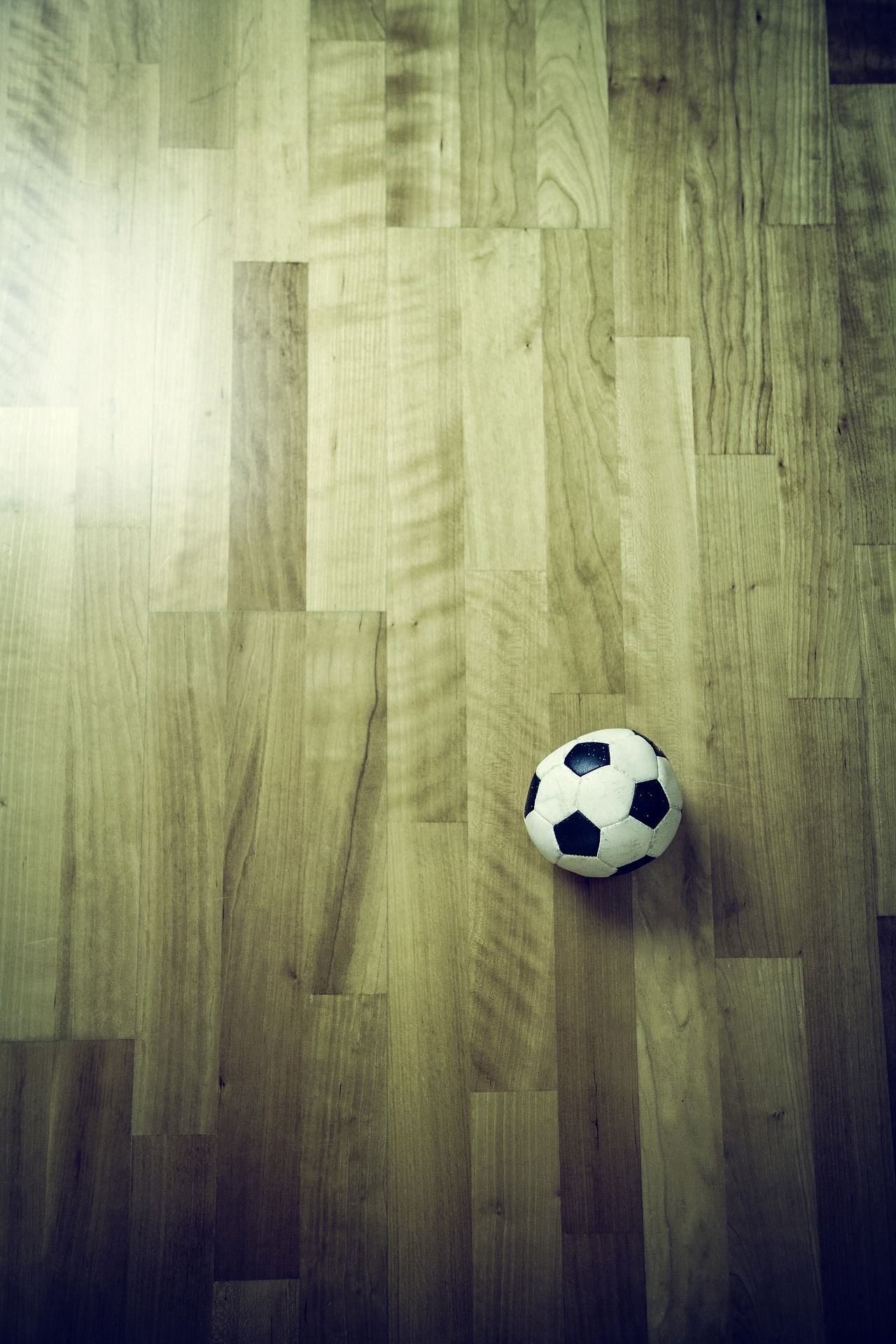 Ein Fußball liegt auf Parkett.