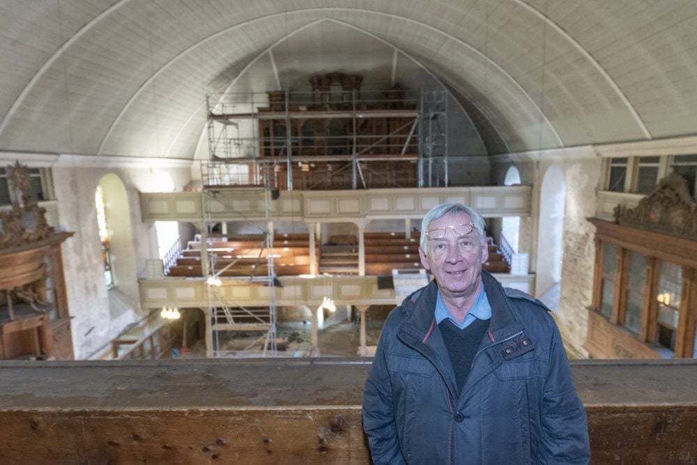 Rainer Schulze hat sein Projekt Konzertkirche durchgeboxt. Hinter ihm ist die gewölbte Decke aus Fichtenholz zu sehen, die dem Konzertsaal seine besondere Akustik verleiht.