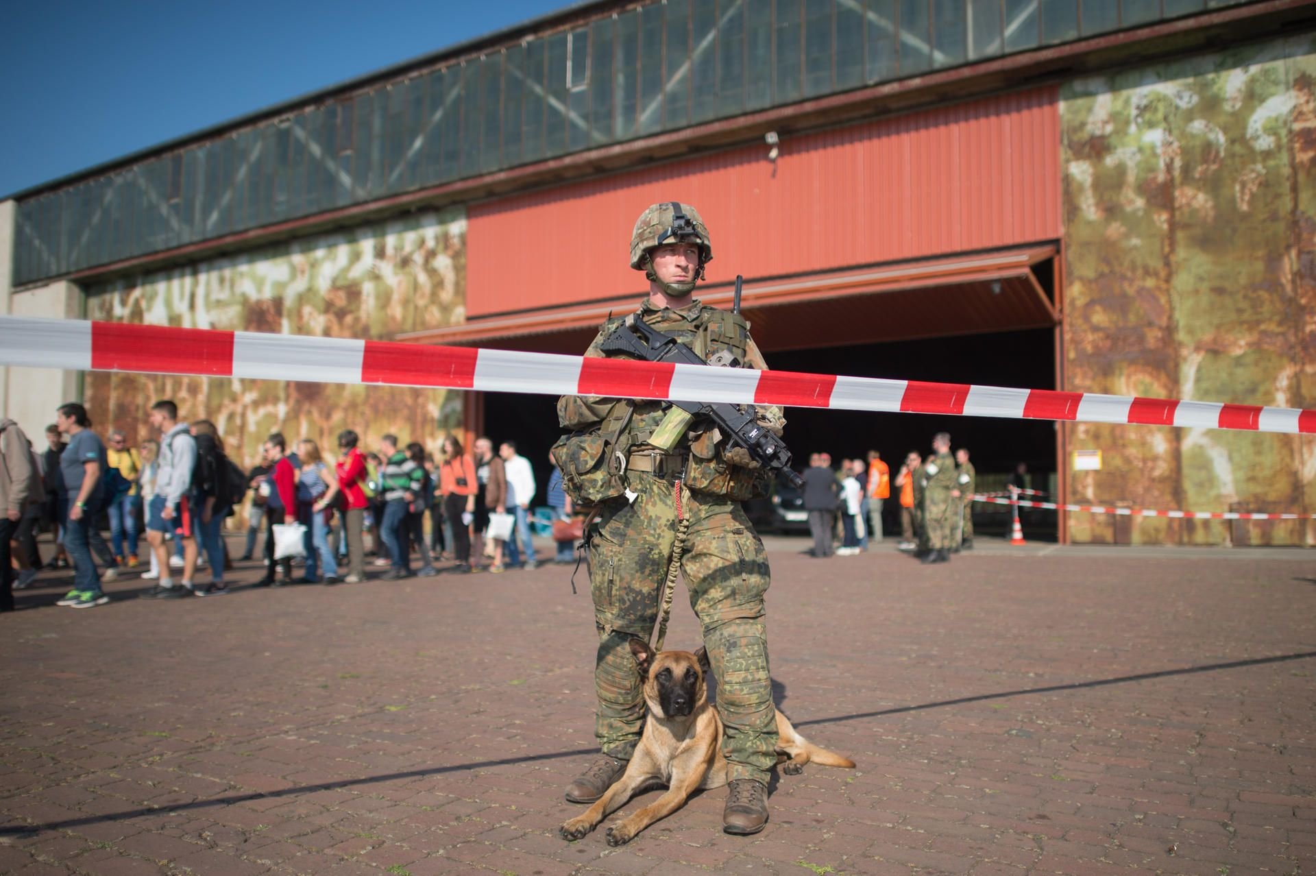 Ein Fallschirmjäger mit Diensthund sichert auf dem Flugplatz die Evakuierung von Bundesbürgern die von Statisten gespielt werden.
