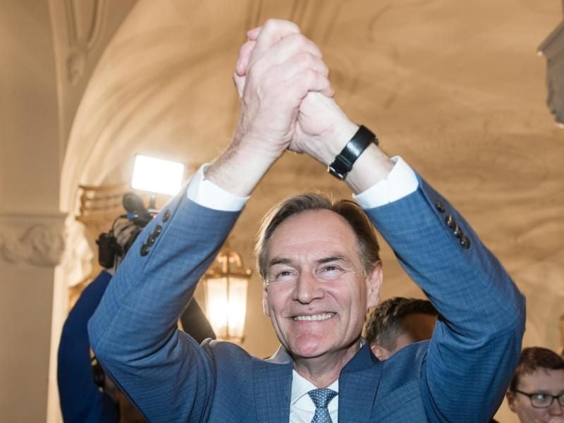 Burkhard Jung (SPD), der wiedergewählte Oberbürgermeister von Leipzig, jubelt beim Betreten des Rathauses. Foto: Hendrik Schmidt/dpa-Zentralbild/dpa