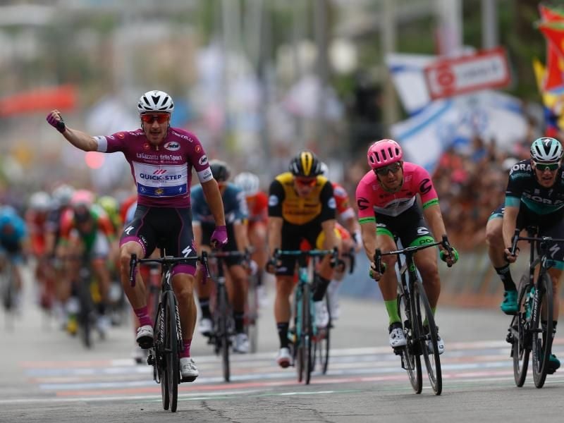Elia Viviani (l) von Team Quick-Step Floors freut sich hinter der Ziellinie über seinen Sieg. Foto: Ariel Schalit/AP