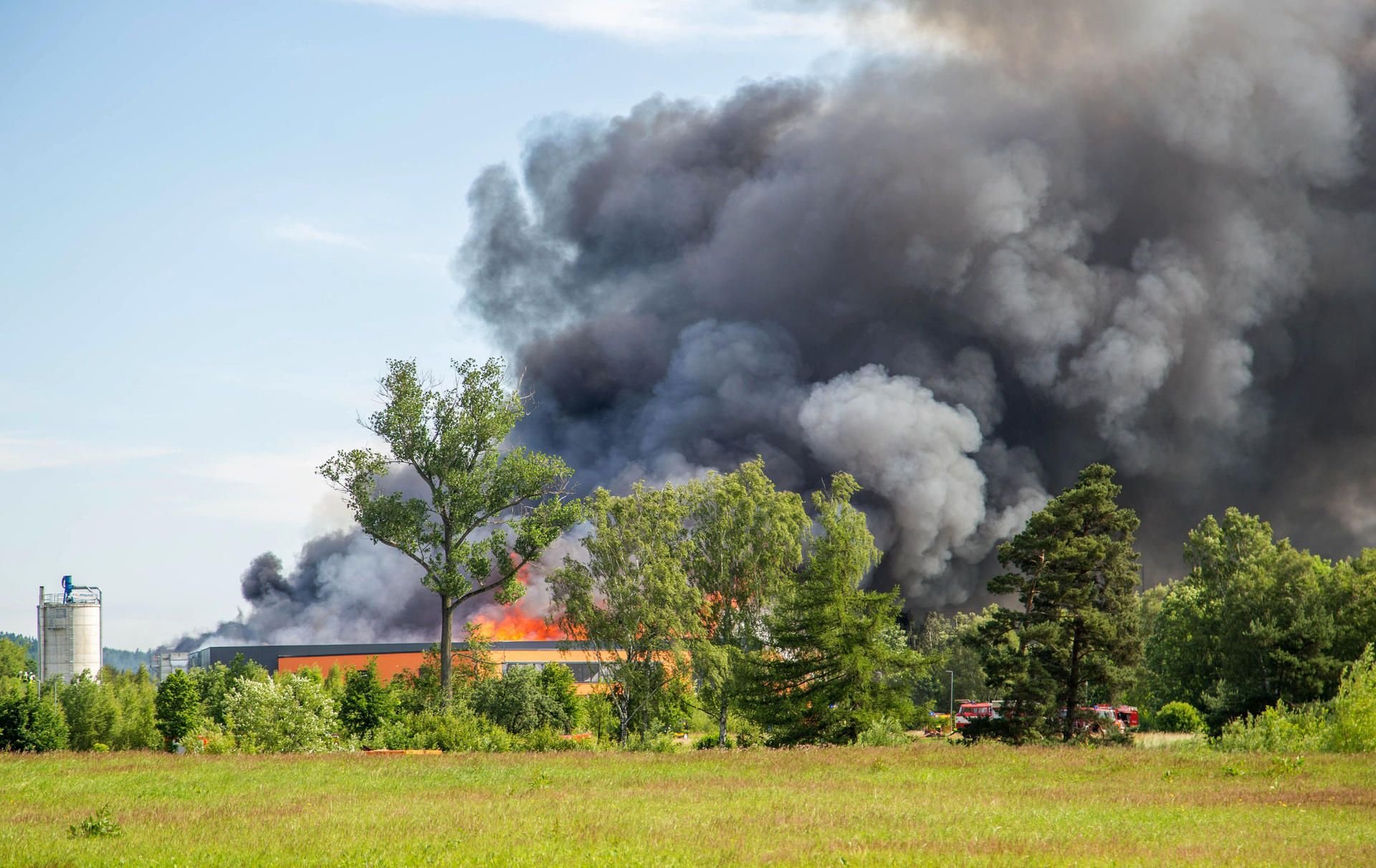Flammen und eine Rauchwolke schlagen aus dem Gebäude einer Möbelfabrik in Elterlein (Sachsen).