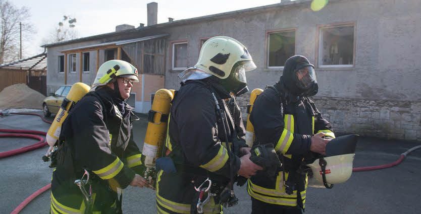Wohnhausbrand in Marienthal bei Eckartsberga. Feuerwehrleute mit Atemschutzgeräten stellen sicher, dass niemand mehr im Gebäude ist.