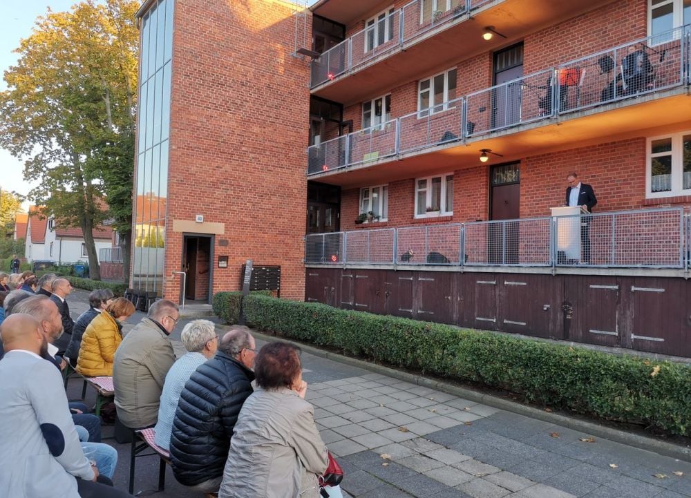 Sitzreihen vor dem Laubenganghaus: Nicky Meißner begrüßt die Gäste.