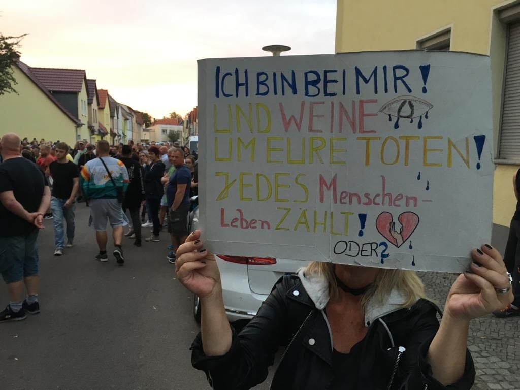 Eine Frau hält bei dem Trauermarsch dieses Schild nach oben.
