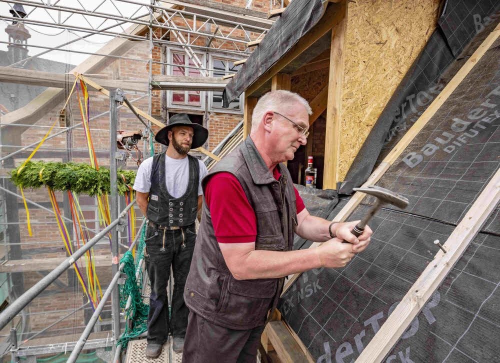 Bauherr Frank Guhl schlägt den letzten Nagel ins Holz.