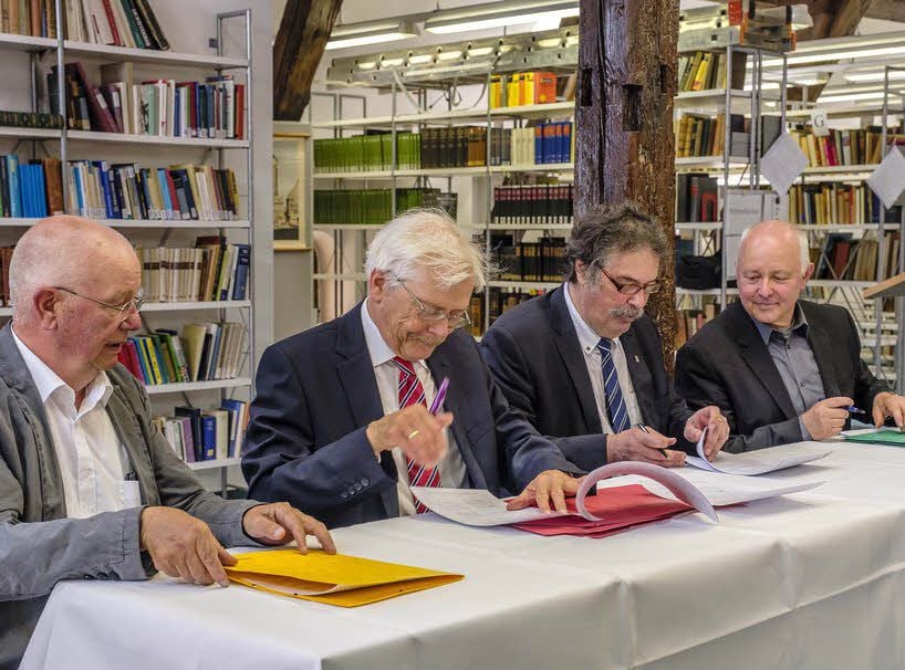Die Professoren Ernst-Joachim Waschke, Gerhard Meiser, Walter Krämer und Hans-Joachim Solms (v. l.) unterzeichnen das Gründungsdokument.
