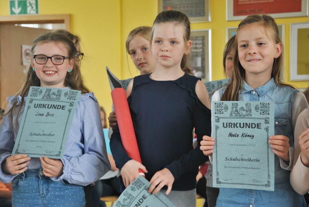 Die künftigen Schulschreiber aus der dritten Klasse erhalten ihre Ernennungsurkunden und symbolisch einen großen Federhalter.