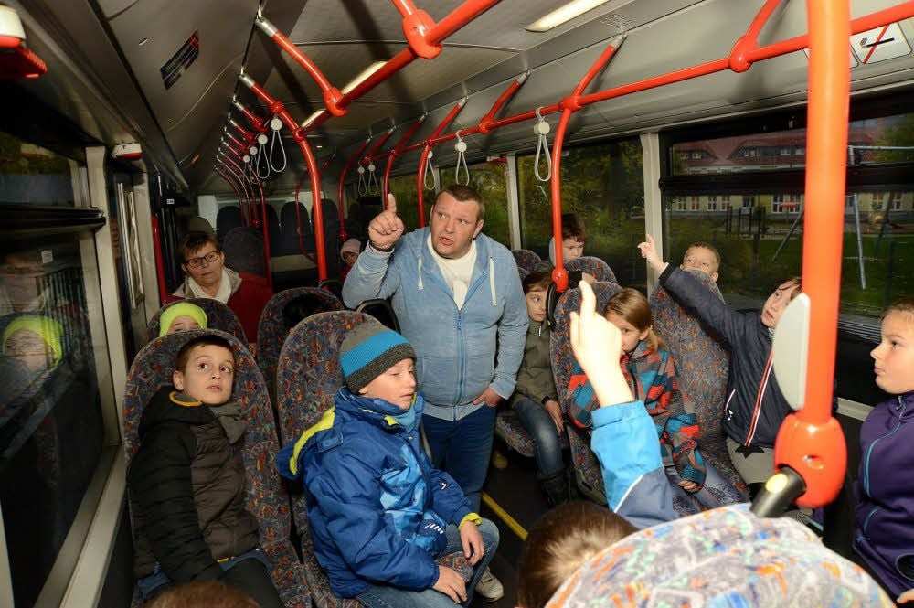 Busfahrer René Nachsel erklärt den Zweitklässlern der Grundschule Tröglitz, wo der Hammer für Notfälle im Bus hängt.