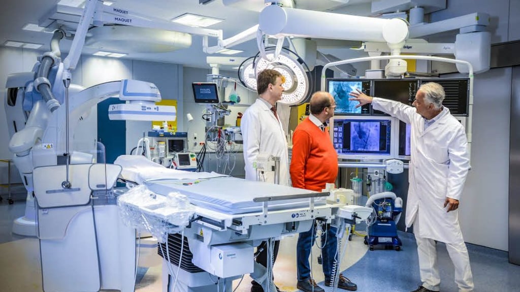 Die Ärzte Harald Hausmann (rechts) und Tom Giesler (links) erklären ihrem Patienten Dietmar Gericke im modernen Hybrid-OP, wie das Herz des Menschen funktioniert und die Herzklappen-Operation abläuft.