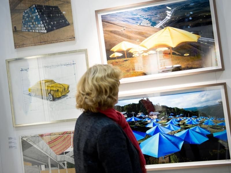 Eine Frau betrachtet Bilder auf der Kunstmesse "Affordable Art Fair" in Hamburg. Foto: Daniel Reinhardt/dpa/Archivbild