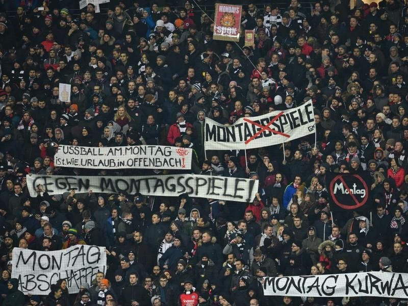 Fans von Eintracht Frankfurt hielten zu Spielbeginn Plakate als Protest gegen das Montagsspiel in die Höhe. Foto: Uwe Anspach
