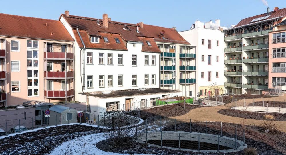 Blick auf das Wohnquartier „Tiefer Keller“ mit dem begehbaren Parkdeck. Das weiße Gebäude in der Mitte mit dem alten Anbau wird jetzt saniert.