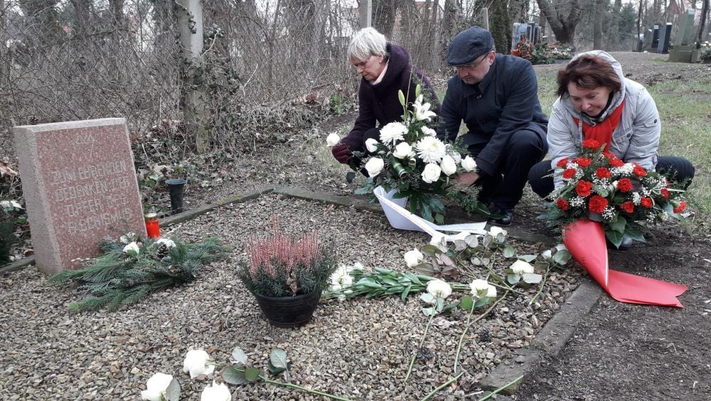 Ellen Fauser von der Interessengemeinschaft Todesmärsche (von links), Könnerns Bürgermeister Mario Braumann (parteilos) und Stadträtin Martina Schaar (Linke) legen Blumen am Grab für die Opfer des Faschismus nieder.