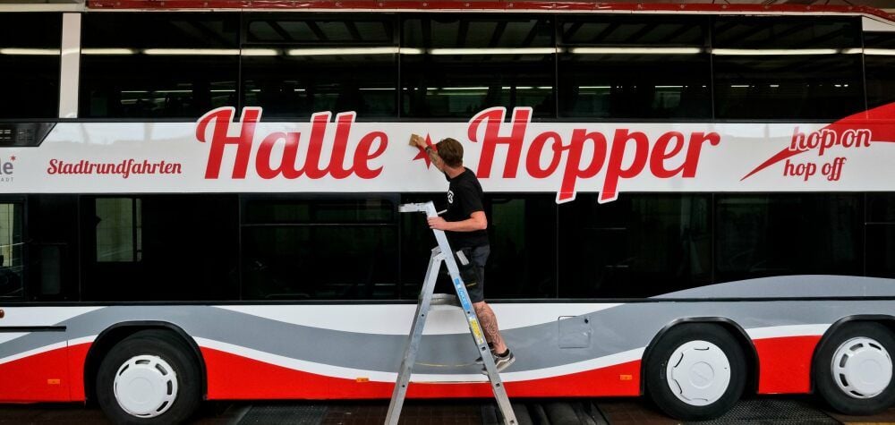 Sven Macha streicht eine Folie am neuen „Halle-Hopper“ glatt.